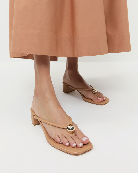 Odessa Dune Leather Heeled Sandal in dune tan leather with a gold ball accent and Estelle Dress in light brown cotton.